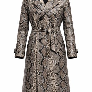 Op de afbeelding: Lange trenchcoat met een slangenprint in bruin, grijs en zwart. De dubbele rij jas heeft een riem, revers en knopen. Een modieus kledingstuk voor buiten.