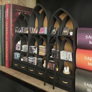 Gothic dollhouse bookcase with arches and drawers displayed in a moody styled interior, miniature 1:12 scale library wall
