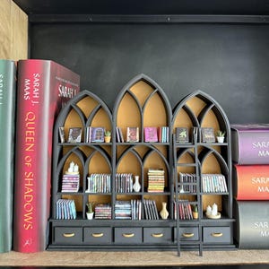 Gothic dollhouse library bookcase styled with full-size books for scale, showing pointed cathedral arch design