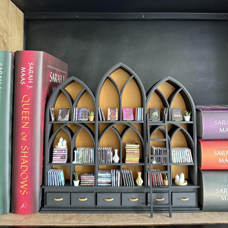 Gothic dollhouse library bookcase styled with full-size books for scale, showing pointed cathedral arch design