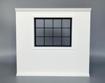 Könnte beinhalten: Ein weißer Wandabschnitt mit einem mittig platzierten Fenster, das einen schwarzen Rahmen und ein Gitter aus zwölf quadratischen Scheiben aufweist. Die Wand hat oben eine Zierleiste und unten eine Sockelleiste für eine klare Optik.