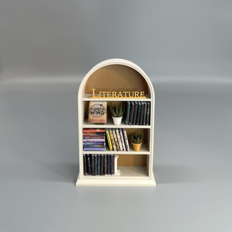 Miniature arched bookcase with literature sign and tiny books on grey background