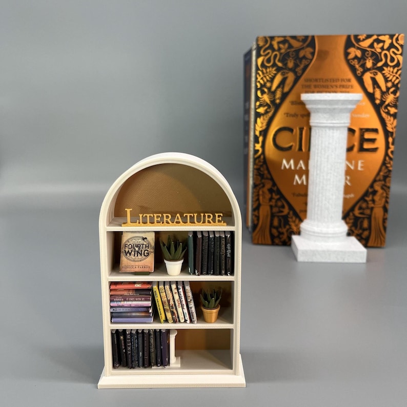 Miniature arched bookcase styled next to large novel for size comparison