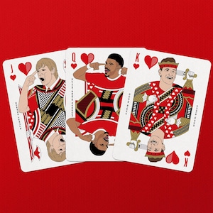 May include: Three playing cards featuring illustrations of people in red and white outfits. The cards are the Jack, Queen, and King of Hearts. The background is solid red.
