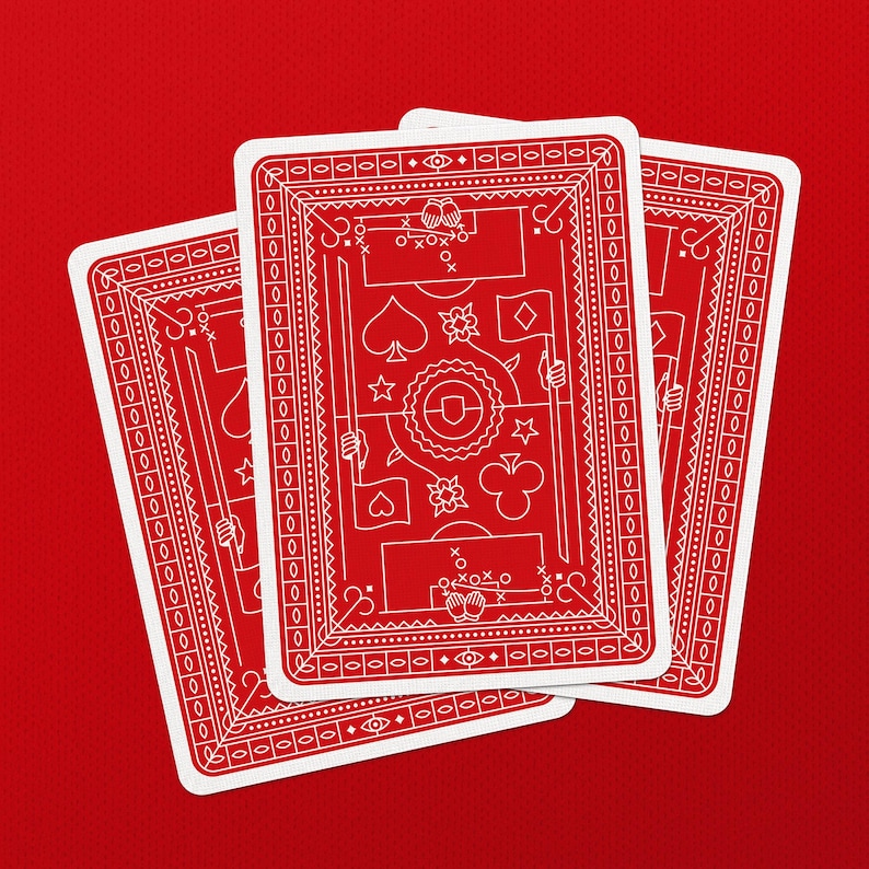 May include: Three playing cards with a red background. The cards have a red face with white decorative elements and suit symbols. The cards are fanned out, showing the backs of the cards.