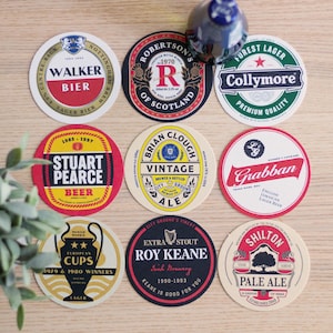 May include: Nine round beer coasters with various logos and text, including "Walker Bier," "Robertson's of Scotland," and "Collymore Forest Lager." The coasters feature a variety of colors and designs, perfect for a bar or home.