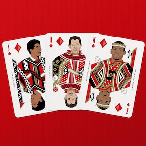 May include: Three playing cards featuring illustrations of people, with a red background. The cards are the Jack, Queen, and King of Diamonds. The Jack card features Des Walker, the Queen card features Andy Reid, and the King card features Stan Collymore.