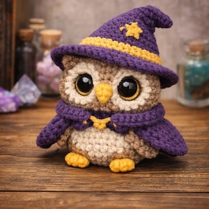 May include: Crocheted owl figurine wearing a purple witch hat with a yellow star and a matching scarf. The owl has large, expressive eyes and yellow feet. The handmade owl is sitting on a wooden surface.