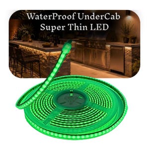 Puede incluir: Una tira de luz LED verde enrollada en un carrete de plástico, con el texto WaterProof UnderCab Super Thin LED. La tira emite un brillo verde intenso, y la imagen muestra una cocina exterior con encimeras de piedra y electrodomésticos de acero.