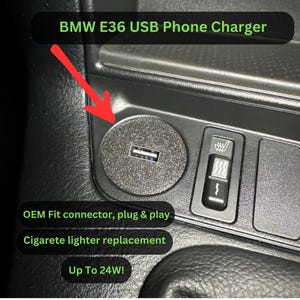 Może przedstawiać: Czarne wnętrze samochodu z ładowarką USB do telefonu. Ładowarka zastępuje zapalniczkę i jest oznaczona jako "BMW E36 USB Phone Charger". Widoczny jest również tekst "OEM Fit connector, plug & play" oraz "Up To 24W!"