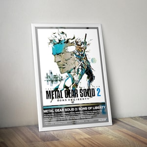 May include: A framed poster for the video game Metal Gear Solid 2: Sons of Liberty. The artwork features a stylized illustration of a character with blue accents and the game's title. The poster is leaning against a wooden surface.