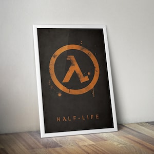 Op de afbeelding: Een ingelijste poster met het Half-Life-logo in oranje op een donkergrijze achtergrond. Het logo is een lambda-symbool in een cirkel, met de woorden "HALF-LIFE" eronder in oranje. De poster zit in een witte lijst.