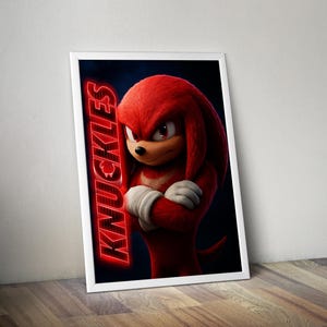 May include: A framed poster featuring Knuckles from the Sonic the Hedgehog movie. The character is red with white gloves and a stern expression. The word "KNUCKLES" is displayed vertically in red neon.