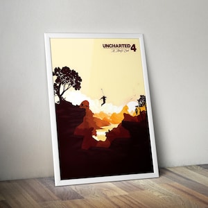 以下が含まれることがあります： 「UNCHARTED 4 A Thief's End」のテキストが入った、人が峡谷を渡るシルエットの額入りポスター。暖色系のオレンジと茶色を基調とし、明るい黄色の空が特徴です。