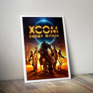 Puede incluir: Un póster enmarcado del videojuego "XCOM: Enemy Within". La obra presenta siluetas frente a un gran robot, con un fondo azul y naranja brillante. El título del juego se muestra en letras doradas.