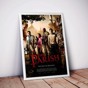 May include: Framed poster with a group of people holding weapons, set against a church and sunset backdrop. The red title reads "The Parish", with the tagline "This Time It All Goes South". The poster is in a white frame.