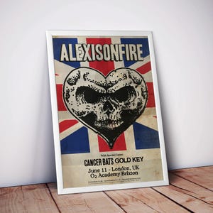 May include: A framed poster for the band Alexisonfire, featuring a heart-shaped skull design over a Union Jack background. The poster also lists the special guests Cancer Bats and Gold Key, with the date June 11 and the location O2 Academy Brixton, London, UK.