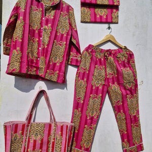 May include: A matching pink pajama set with a tiger print, including a button-down shirt, pants, and a small clutch. A tote bag with the same tiger print is also included. The set is made of a soft fabric and is perfect for lounging.