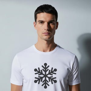 Op de afbeelding: Wit T-shirt met een donkergrijze sneeuwvlok op de voorkant. De sneeuwvlok is gecentreerd. Het shirt heeft een ronde hals en is gemaakt van een gladde, lichte stof.