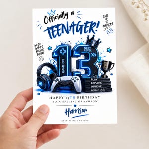 May include: A birthday card featuring the text Officially a TEENAGER! and Happy 13th Birthday to a special grandson Harrison. The design includes a large number 13, a gaming controller, headphones, a trophy, and the words Play Explore Improve Repeat.