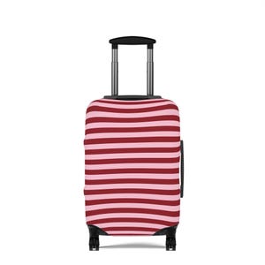 May include: A wheeled suitcase with a retractable handle. The case features horizontal stripes in alternating light pink and dark red. The wheels and handle are black.