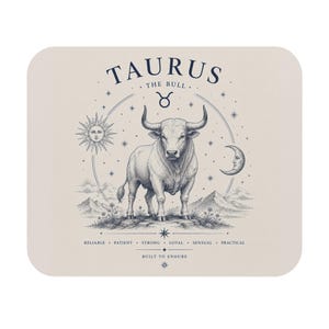 May include: A rectangular mouse pad with a light beige background featuring a dark blue illustration of a bull. Text includes TAURUS THE BULL, the Taurus symbol, and the words RELIABLE, PATIENT, STRONG, LOYAL, SENSUAL, PRACTICAL, and BUILT TO ENDURE.