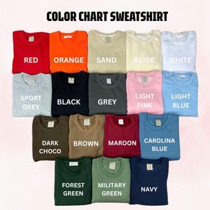 May include: A color chart sweatshirt display featuring seventeen crewneck sweatshirts in various solid colors including red, orange, sand, beige, white, sport grey, black, grey, light pink, light blue, dark choco, brown, maroon, carolina blue, forest green, military green, and navy.