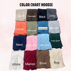 May include: A color chart for hoodies featuring folded fabric samples in various shades including sand, chocolate, black, grey, orange, military green, Carolina blue, sport grey, navy, light pink, light blue, forest green, white, maroon, brown, and beige.