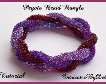 May include: A peyote braid bangle bracelet made with purple, red, and blue beads. The bracelet is twisted and has a braided design. The image text reads "Peyote Braid Bangle Tutorial" and "Intricates By Deb".