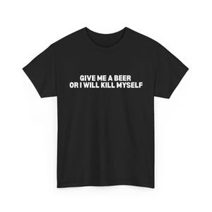 Può includere: T-shirt nero con la scritta bianca "GIVE ME A BEER OR I WILL KILL MYSELF". La maglietta è a girocollo e sembra essere realizzata in un materiale morbido.