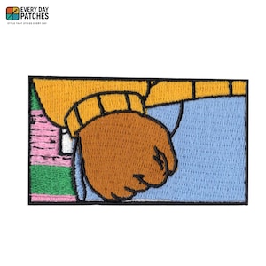 Puede incluir: Parche bordado con un choque de puños de dibujos animados. El parche tiene un puño marrón, una manga amarilla y un fondo azul claro. El parche también tiene el texto "EVERY DAY PATCHES" y "STYLE THAT STICKS EVERY DAY".