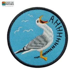 May include: Embroidered patch with a seagull design, open-mouthed and the word "AHHHHH" on a light blue background. The patch has a black border and the text "EVERY DAY PATCHES" at the top. Ideal for jackets, bags, or clothing.