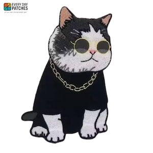 May include: Embroidered patch featuring a cool cat wearing sunglasses and a gold chain. The cat has black and white fur and is dressed in a black shirt. The patch has the text "EVERY DAY PATCHES" at the top.