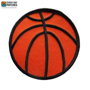 May include: Circular orange basketball patch with black stitched lines and a black border. This sports-themed patch is suitable for attaching to clothing or bags. The patch features the text "EVERY DAY PATCHES" and "STYLE THAT STICKS EVERY DAY".