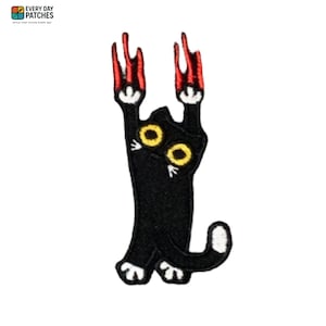 May include: Embroidered patch featuring a black cat with yellow eyes and red claws. The cat is in a playful pose, with its paws raised. The patch has white accents and the text "EVERY DAY PATCHES" at the top.
