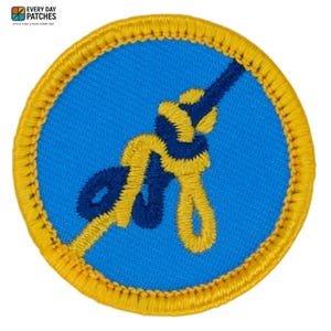 Peut inclure: Écusson rond brodé avec un fond bleu et un motif de corde jaune et bleu. L'écusson a une bordure jaune et le texte "EVERY DAY PATCHES" en haut.