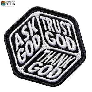 Pode incluir: Patch bordado em preto e branco com as palavras "ASK GOD", "TRUST GOD" e "THANK GOD". O patch tem uma borda preta e texto branco, com uma forma geométrica.