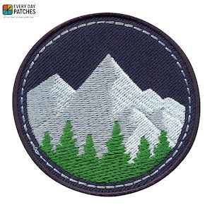 Könnte beinhalten: Gestickter Aufnäher mit einer Bergkette und immergrünen Bäumen. Das Design befindet sich in einem marineblauen Kreis mit einem weiß genähten Rand. Der Text "EVERY DAY PATCHES" befindet sich oben.