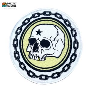 Könnte beinhalten: Runder Aufnäher mit einem weißen Totenkopf, einem schwarzen Stern und einem Kettenmuster. Der Totenkopf befindet sich auf einem hellgelben Hintergrund, umgeben von einem schwarzen Kettenrand. Der Aufnäher trägt oben den Text "EVERY DAY PATCHES".