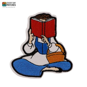Peut inclure: Un écusson brodé représentant une silhouette aux cheveux bruns assise en tailleur, lisant un grand livre rouge. La silhouette porte une chemise blanche à manches longues avec un corsage bleu et une jupe bleue, et tient un panier en osier marron.