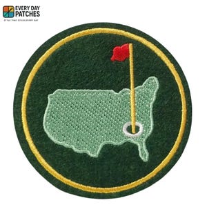 以下が含まれることがあります： ゴルフの旗と穴が付いた、米国の薄緑色の輪郭が特徴の、丸くて緑色の刺繍パッチ。 パッチには黄色の縁取りがあり、上部に「EVERY DAY PATCHES」というテキストがあります。