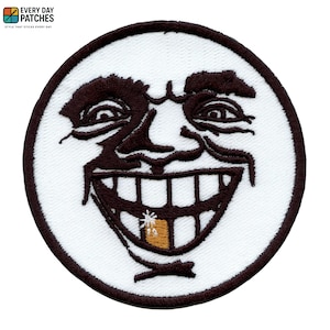 Könnte beinhalten: Runder, gestickter Aufnäher mit einem lächelnden Gesicht mit dunkelbraunen Gesichtszügen und einem breiten Grinsen. Das Gesicht befindet sich vor einem weißen Hintergrund mit einem dunkelbraunen Rand. Der Aufnäher enthält oben den Text "EVERY DAY PATCHES".