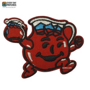 Op de afbeelding: Geborduurde patch met een rood stripfiguur met een lachend gezicht, die een drankje vasthoudt. Het personage heeft witte en blauwe accenten op zijn hoofd en is zwart omlijnd. De patch heeft de tekst "EVERY DAY PATCHES" en "STYLE THAT STICKS EVERY DAY".