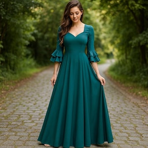 Puede incluir: Vestido largo de color verde azulado con escote corazón y mangas acampanadas. El vestido tiene un corpiño ajustado y una falda fluida, ideal para eventos formales. El vestido está hecho de una tela suave y fluida.