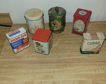 Lote de latas antiguas que incluyen Curad, Band-Aid, Suzy's Zoo, Murray Allen y Whitman.