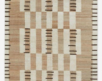 May include: A rectangular rug with a geometric pattern. The rug features alternating vertical stripes of beige and off-white, with sections of brown horizontal lines. The border is defined by vertical brown lines.