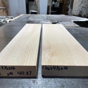 May include: Two light-colored wooden planks, each with dimensions written on the side. The first plank is 1 1/16" x 3 1/2" x 16", and the second is 1 1/16" x 4 1/2" x 16".