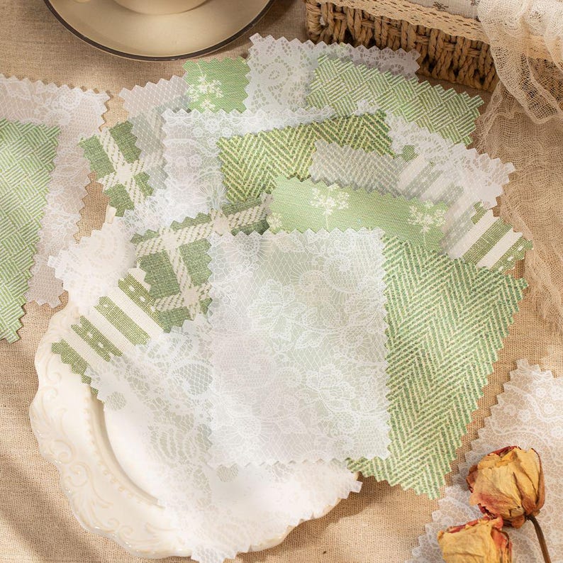 May include: A collection of rectangular fabric swatches featuring various shades of green and white. The patterns include white floral lace, green and white herringbone, plaid, and botanical prints with pinked edges, layered on a white plate.