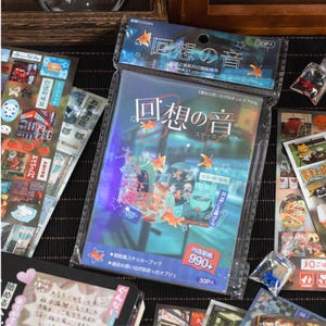 Japanese retro aesthetic sticker book with 900 mixed stickers, hand-held cover display for journaling and scrapbooking.