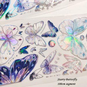 May include: A sheet of iridescent butterfly stickers in shades of purple, blue, and white. The stickers have a holographic effect and are labeled "Starry Butterfly" and "100cm segment".